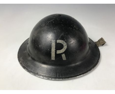 A Second World War Civil Defense helmet bearing the initial R in white