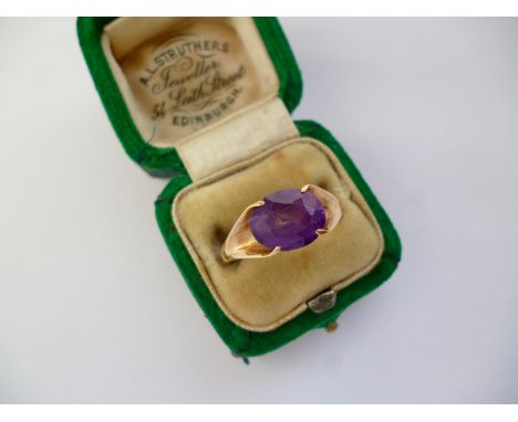 A vintage 9ct gold and amethyst dress ring, the oval-cut stone being claw set and flanked by cleft shoulders, 3g