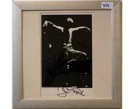 A mounted and framed photo print depicting Bowie on stage, signed to lower border by David Bowie and dated 2001. Provenance: 