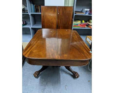 An early 19th century pedestal extending mahogany dining table with two extra leaves, rectangular top with rounded edges and 