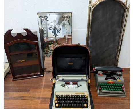 A mixed lot to include two vintage typewriters, a display cabinet, a fire screen, and a mirrored wall panel with floral desig