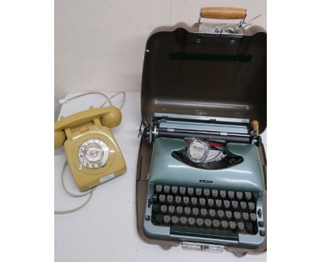 Imperial Good Companion 3 typewriter in metal case, a mustard cased dial telephone, and a 1940s oak cased mantle clock (3) 