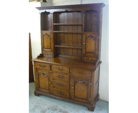 Georgian style oak dresser with three shelves flanked by cupboards and drawers, base with six drawers and two cupboards, on b