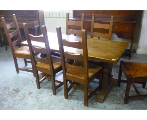 Oak dining table with trestle ends and a set of six ladder back rush seated chairs 