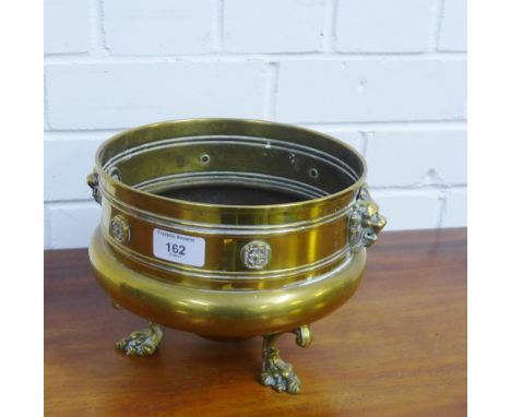 A bronze circular planter on three cast paw feet