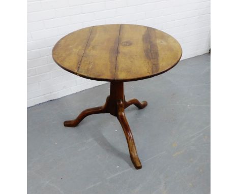 A mahogany circular topped drop flap table on tripod supports, 72 x 90cm 