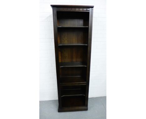 A dark elm Ercol bookcase with carved cornice to top and raised on a plinth base, 98 x 68cm 