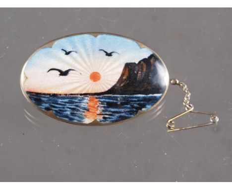 A Norwegian silver gilt and enamel brooch, decorated seascape with cliffs and birds
