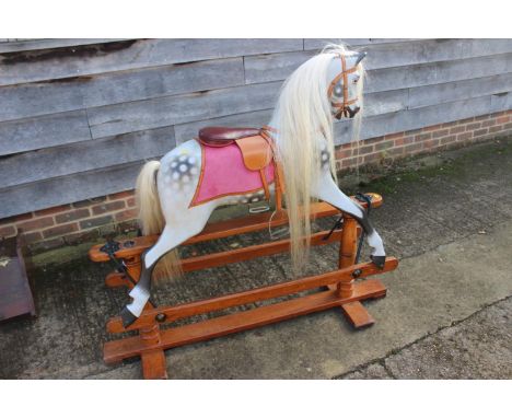 An early 20th century rocking horse with horse hair tail and mane, on faceted pine stand, 52" wide x 45" high