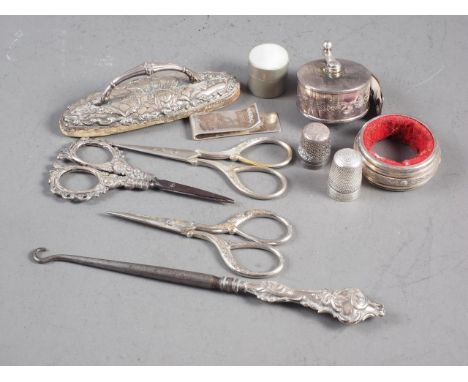 A pair of silver handled scissors, two other pairs of scissors, two silver thimbles, a silver mounted nail buffer, a silver h