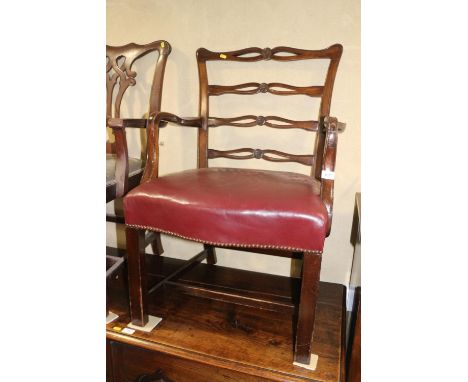 A Sheraton Revival carved mahogany ladder back elbow chair with stuffed over seat, upholstered in a burgundy leather