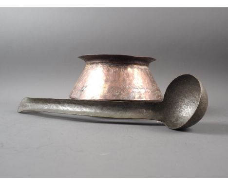 A 19th century Burmese hammered copper bowl, 9" max dia, and a silvered hammered copper ladle with shaped handle, 17" long