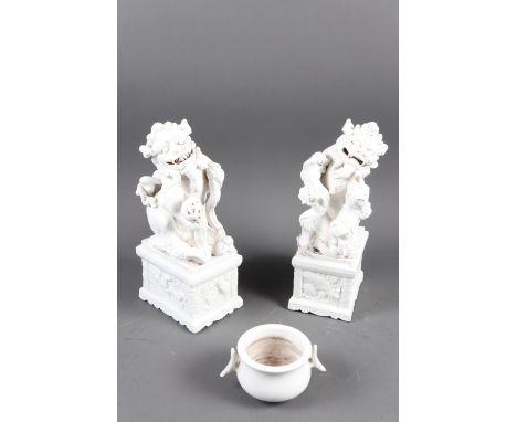 A pair of Chinese blanc-de-chine model Dogs of Fo, on block bases with panelled decoration, 10 1/2" high, and a similar two-h