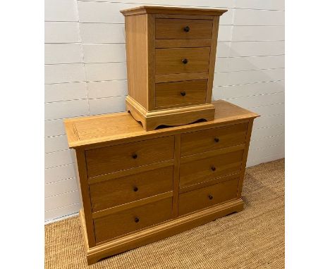A light oak chest of drawers along with a single bedside (H88cm W132cm D45cm) (Bedside H68cm W51cm D45cm)