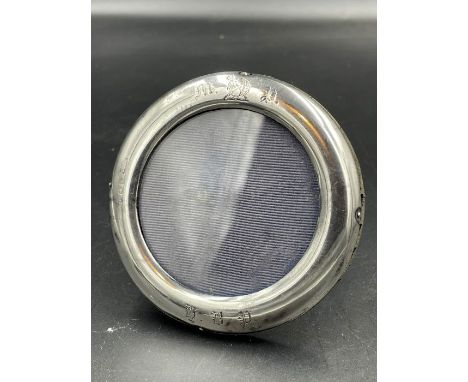 A small round silver picture frame, indistinct hallmarks, approximately 8cm diameter, easel back.