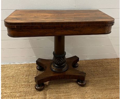A George IV style card table with rectangular top folding to enclose a blaze on turned column (H74cm W92cm D45cm folded)