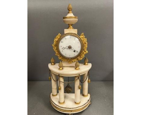 A white marble and brass shelf clock supported by marble pillars and brass accents 