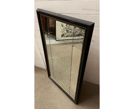 A panelled wall mirror with brass studs in a black gilt frame (80cm x 130cm)