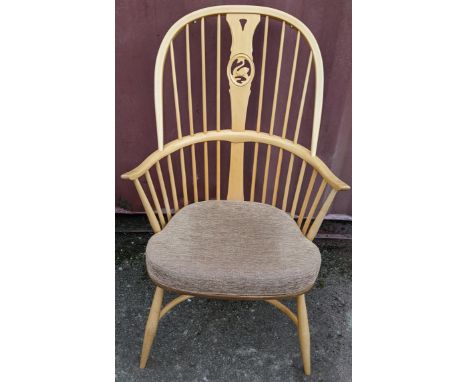 A vintage Ercol light elm and beech 'Swan Back' armchair, with turned legs united by a crinoline stretcher, railed arched bac
