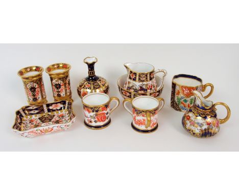 A collection of Royal Crown Derby miniature porcelain including a tyg, mug, pair of vases, baluster vase, pin tray, cream jug