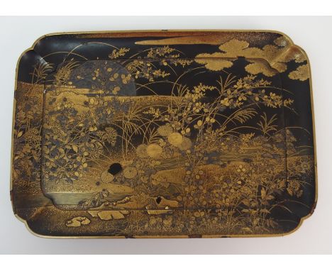 A Japanese rectangular lacquered tray decorated with Maki-e in layers with a foliate foreground before a rising moon (damages