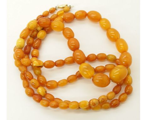 A string of amber coloured beads largest 17.5mm x 14.3mm, smallest 7.1mm x 5.2mm, with a 9ct gold  clasp. Some conchoidal fra