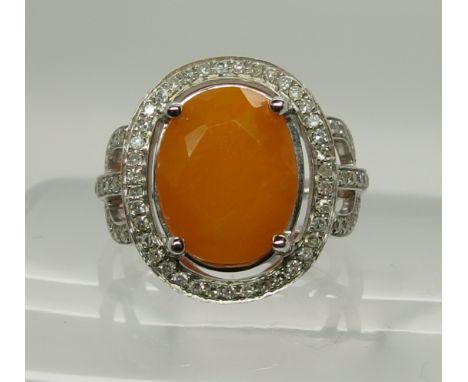 A 14k white gold and diamond ring set with an orange fire opal of approx 4.75cts, diamonds approx 0.50cts combined. Finger si