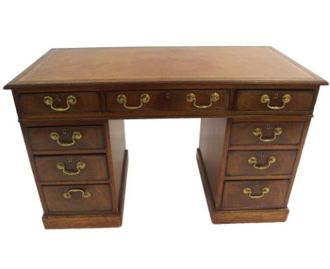 A mahogany twin pedestal desk with leather skiver above a central drawer and two rows of four graduating drawers on plinth ba