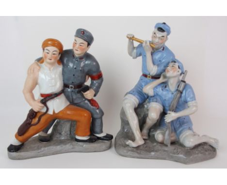 A Maoist Cultural Revolution porcelain model of two soldiers seated on a rock, one playing a flute the other holding a rifle 