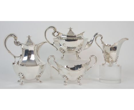 A four piece silver tea service by James Weir, Glasgow 1910, of oval shaped, the faceted body with scrolling handle on four o