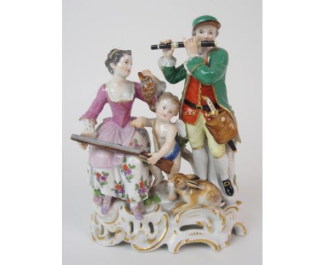 A Meissen style group modelled as a man playing a flute beside a seated lady holding a dead bird, and a cherub between them h