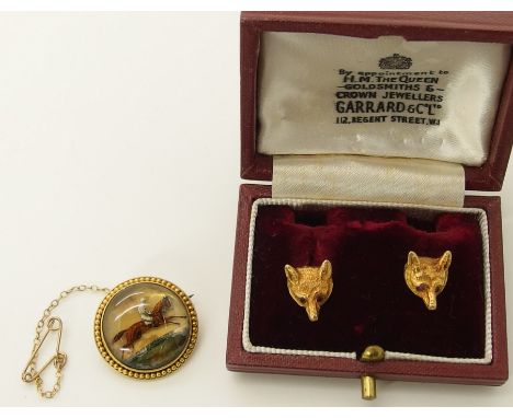 A pair of 9ct gold fox earrings by Garrard & Co with ruby set eyes, 12.2mm long, with post fittings, in original box weight 4
