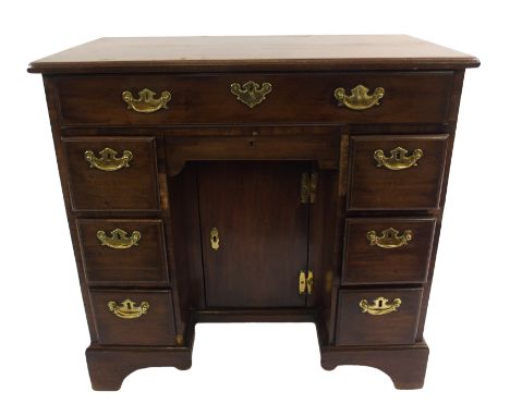 A Georgian mahogany kneehole writing desk with single long drawer above a pair of drawers divided by a central drawer above a