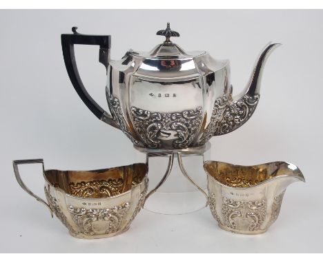 A three piece silver tea service by S. Glass, Birmingham 1902, the fluted body with foliate embossing and blank cartouche, th