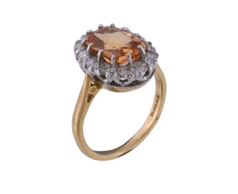  An 18 carat gold orange topaz and diamond ring,   the central rectangular cut orange topaz claw set within a surround of bri