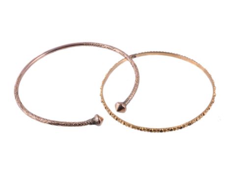  A gold coloured bangle,   with cast detail; together with a further bangle with pointed terminals; 21g gross 