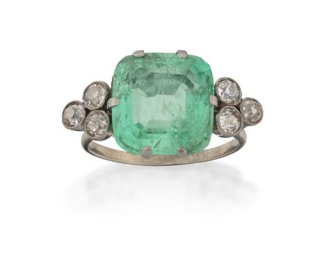 the cushion-shaped emerald, in white claw settings, flanked by trefoils of old cut diamonds, in millegrain settings, to a tap