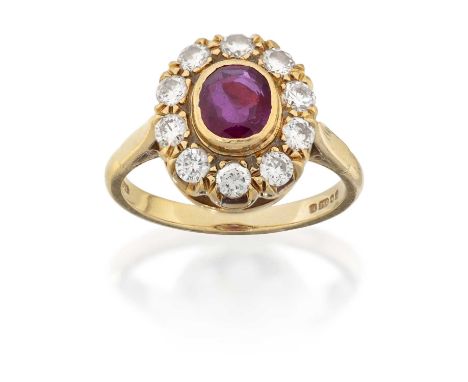 the oval cut ruby in a yellow rubbed over setting, within a border of round brilliant cut diamonds in claw settings, to a tap