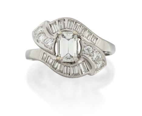 an emerald-cut diamond within a four claw setting, to twist shoulders inset with baguette cut and round brilliant cut diamond