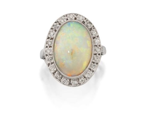 the oval cabochon opal in a millegrain setting, within a border of eight-cut diamonds, to a parted shoulder plain polished sh