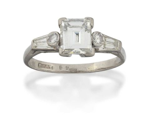 the rectangular step-cut diamond in a white four claw setting, flanked by a round brilliant cut diamond and a tapered baguett