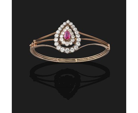 the pear cut ruby within a double spaced border of old cut diamonds, in white collet settings, to a yellow triple row hinged 
