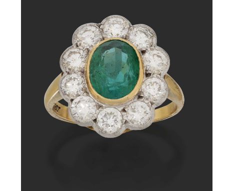 the oval emerald in a yellow millegrain setting, within a border of round brilliant cut diamonds in white millegrain settings