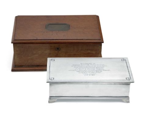 oblong casket-form and on four panel feet, the hinged cover engraved with lines and centring an inscription, opens to reveal 