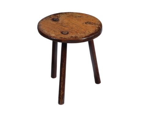 AN OAK TRIPOD LOW STOOL, PROBABLY A MILKING STOOL   19TH CENTURY The circular seat above three legs 37cm high, 32.5cm diamete