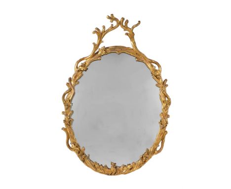 A GILTWOOD OVAL WALL MIRROR WITH EAGLE SURMOUNT  EARLY 20TH CENTURY  The frame decorated with faux bois and with woodland ani