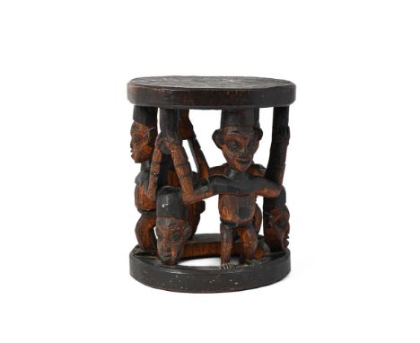 A BAMILEKE STOOL CAMEROON, 20TH CENTURY  carved with three masks and three standing figures with raised arms, with black stai