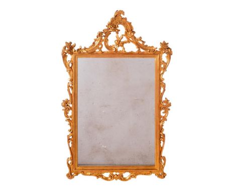 AN ORNATE CARVED GILTWOOD WALL MIRROR ITALIAN, OF RECENT MANUFACTURE 108cm high, 70cm wide, 5cm protuberance Provenance: Priv