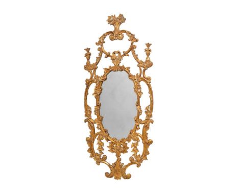 AN ORNATELY CARVED GILTWOOD WALL MIRROR OF PIERCED FORM  IN ITALIAN STYLE  MID 20TH CENTURY  180cm high, 78cm wide, 4cm protu