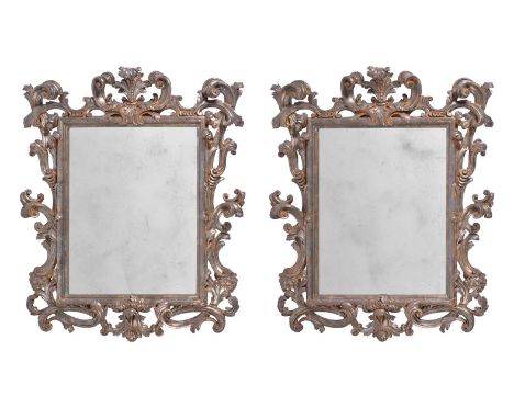 A PAIR OF ORNATE SILVERED WOOD WALL MIRRORS  ITALIAN, 20TH CENTURY  118cm high, 97cm wide, 13cm protuberance  Provenance: Pri